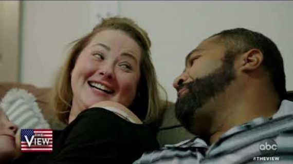 Man and a woman sitting on the lounge laughing