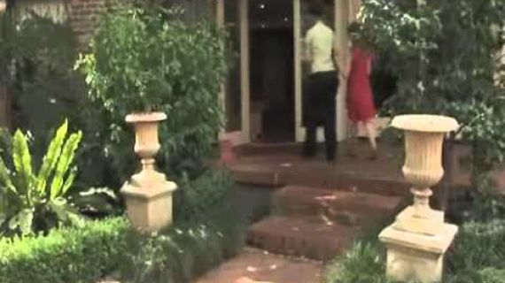 Two people walking to a front door one helping guide the other