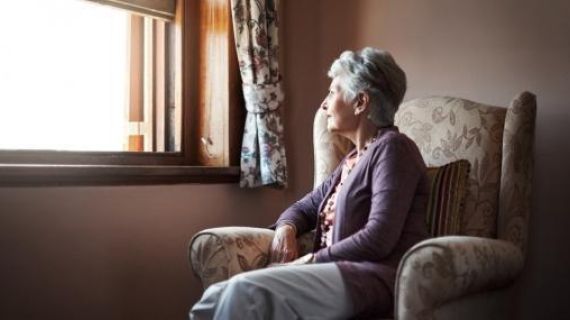 Elderly woman looking out a window