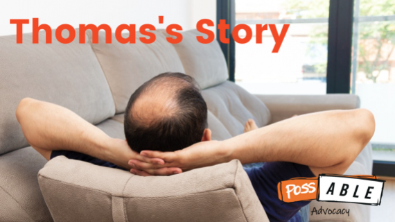 A man rests on a couch. He has his hands behind his head.