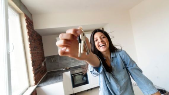 A young lady holding a set of house keys