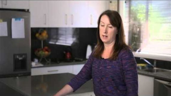Woman standing in her kitchen talking