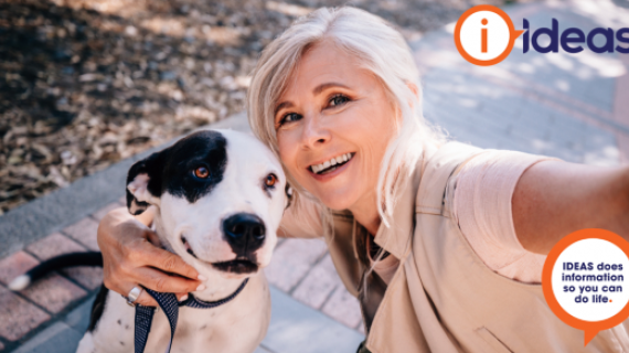 Image of a selfie of a lady and a dog. They are outside and she holds the lead