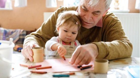 Image of elderly man and little girl colouring in together