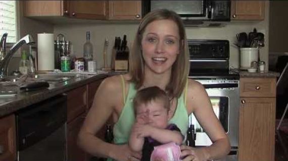 Young woman sitting in a wheelchair holding her baby