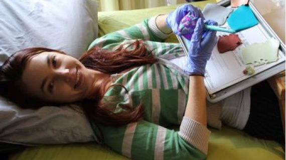 Mel Pym working on Polymer clay while lying down in bed
