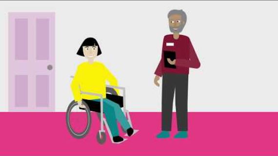 Picture of a lady in a wheelchair with a man holding a notebook standing in front of her