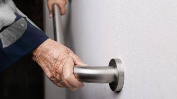 Elderly woman holding onto a grab rail