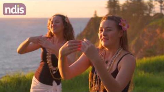 Two young women standing on an islands edge with flower necklaces