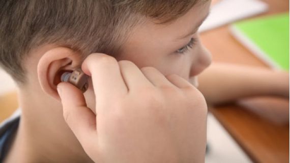 small boy with hearing aid