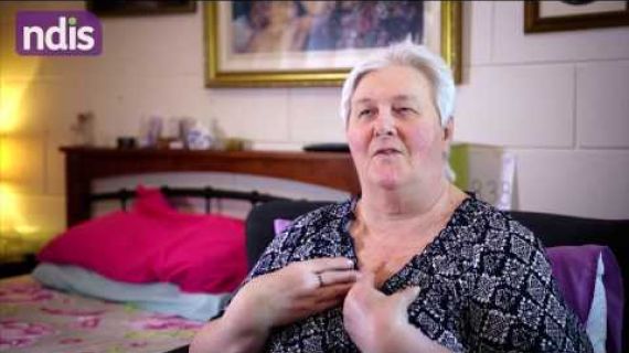 Image of Mary sitting in her bedroom talking