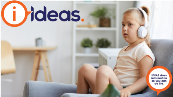 Image of a young girl with disability. She sits in a chair and is wearing headphones.