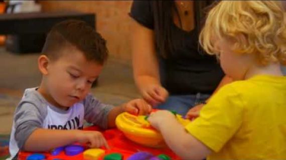 Two kids playing with toys on the floor