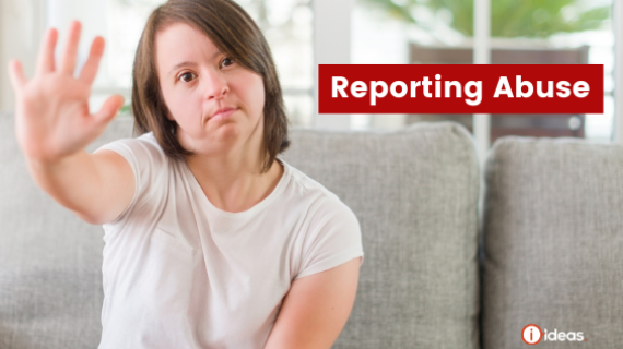 Reporting Abuse - Woman sitting on a couch with her hand up to indicate stop. She has Down Syndrome.ffy dog tha is being held by a woman