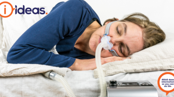 A woman wearing a CPAP machine sleeps.