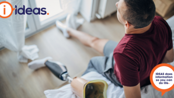 Man is looking out window. Beside him is his prosthetic leg.