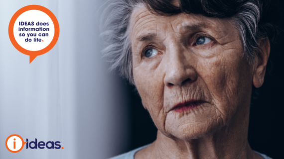 Old woman looking solemnly through a pane of glass