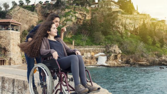 A woman in a wheelchair and her companion looking and pointing at something