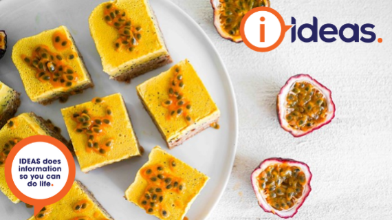 passionfruit slice on a white flat lay with passionfruit in right hand corner