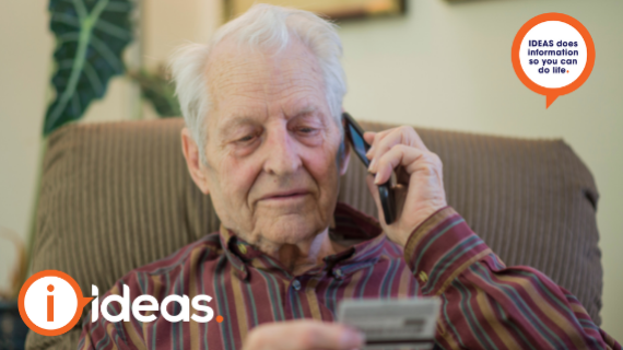Elderly man on phone call holding credit card in hand