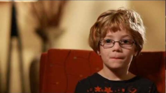 Young boy with glasses sitting in a chair