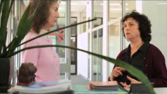 2 women standing in an office talking