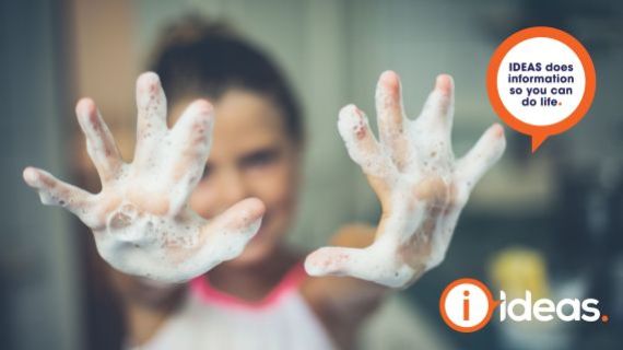 girl holding her soapy hands up