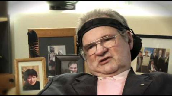 Man sitting strapped in wheelchair speaking