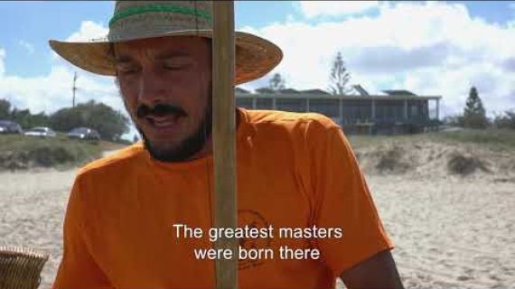 Man at the beach with a straw hat on