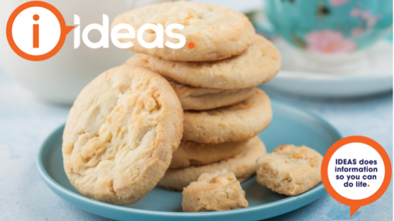 Some plain biscuits stacked on a blue plate, a teacup is in the background.