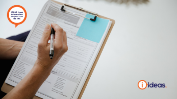 An individual holds a clipboard and pen, filling out a form.