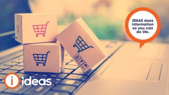 boxes sitting on a laptop keyboard with shopping trolley symbols