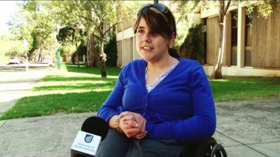 Young lady in a wheelchair sitting outside on the footpath