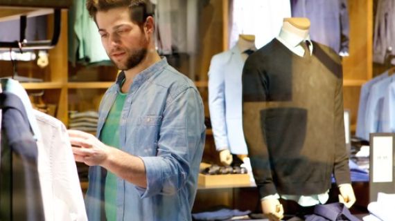 Young man looking at shirts in a shop