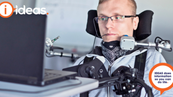 A man with assistive technology is using a laptop.