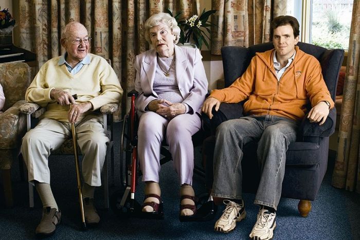 Grayden Moore became a resident in a nursing home at the age of 23. He is one of hundreds of people with disabilities under 50 forced to live in aged care. (Fred Kroh (The Summer Foundation). Shown sitting with two elderly aged care residents.