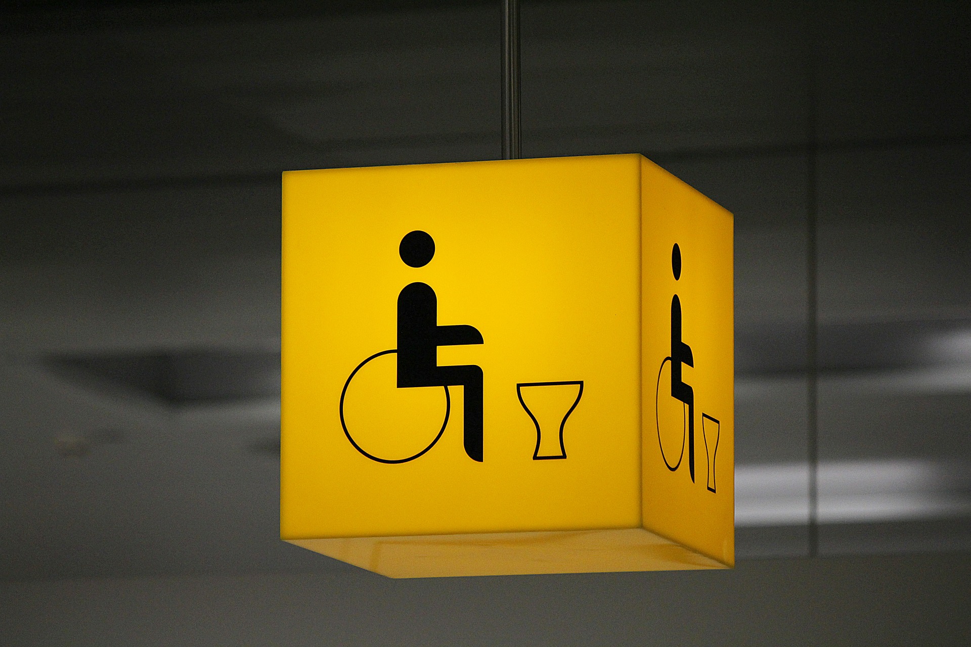 Yellow sign depicting an accessible toilet