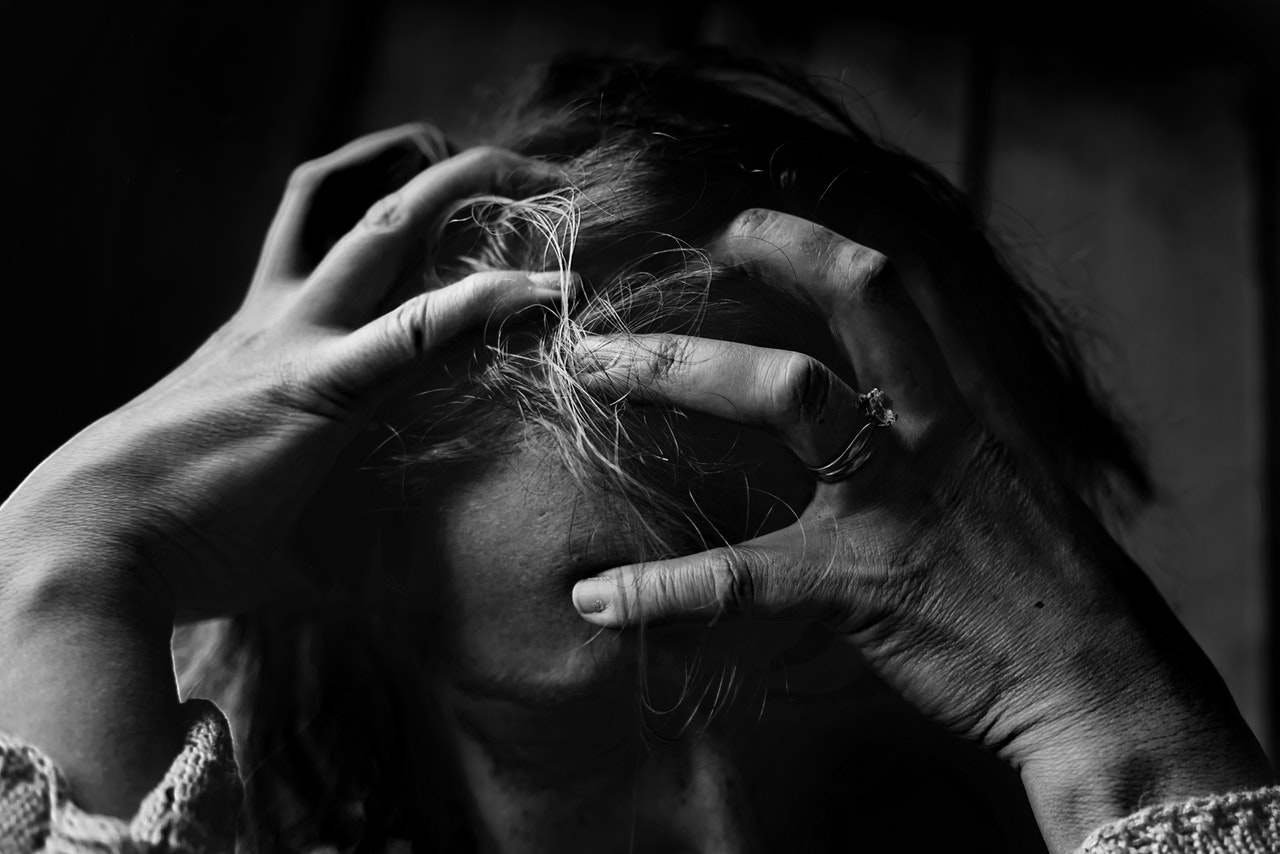 Detail of woman holding her head in frustration. black and white.