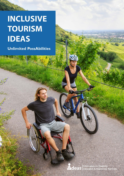 Man in a wheelchair on a path with a woman riding a pushbike beside him