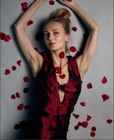 Woman laying down with rose petals all over her