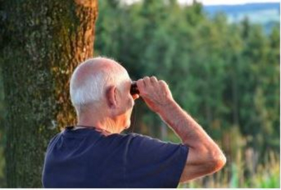 Man looking through a pair of binoculars 